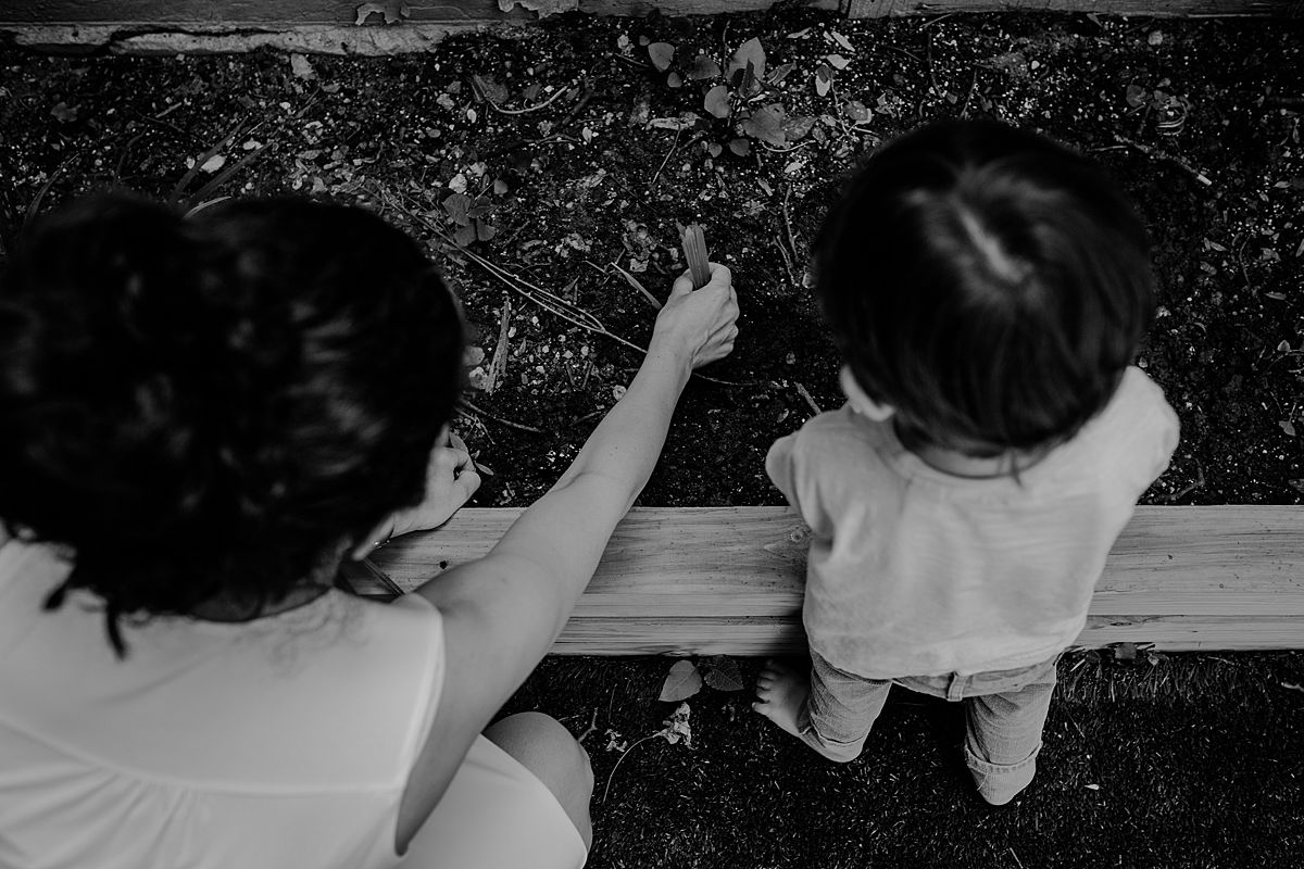 black and white image of mom and son playing in the garden outback during documentary family session. photo by nyc family and newborn photographer krystil mcdowall