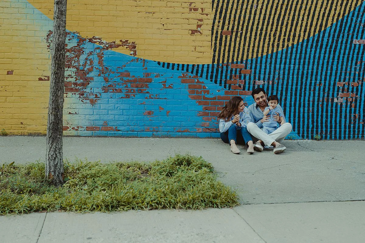 family portrait from afar in front of mural wall. photo by krystil mcdowall