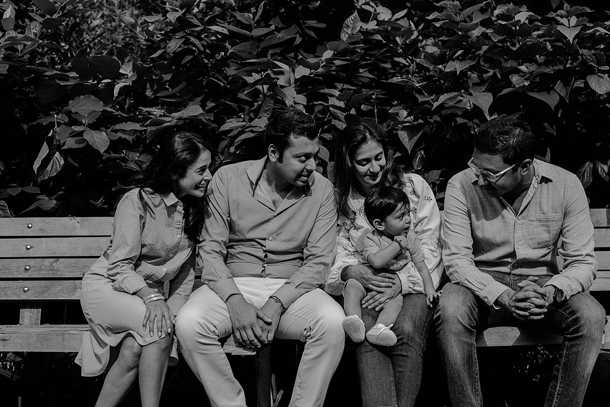 mom, dad, aunty, uncle and newphew in black and white photo in brooklyn bridge park. photo by nyc family and newborn photographer krystil mcdowall
