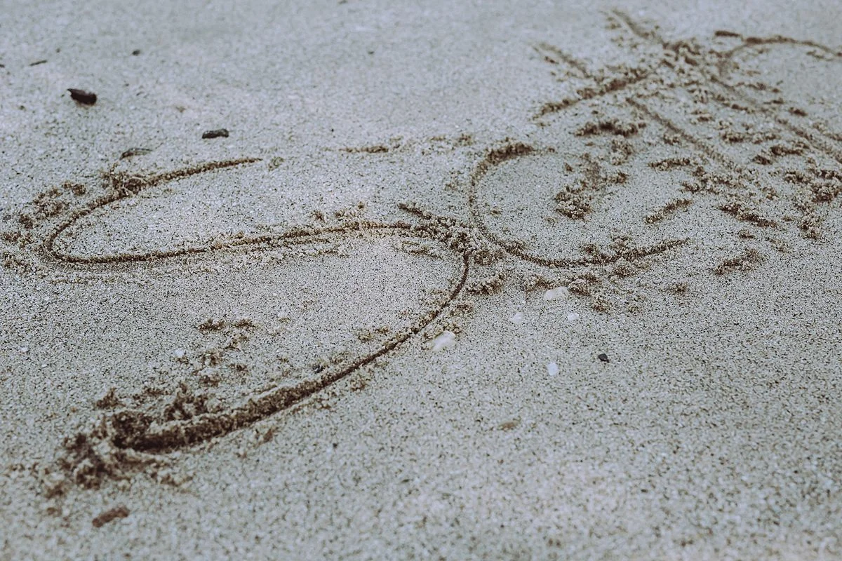 picture of son's name scrolled into sand by the hudson river in washington heights nyc