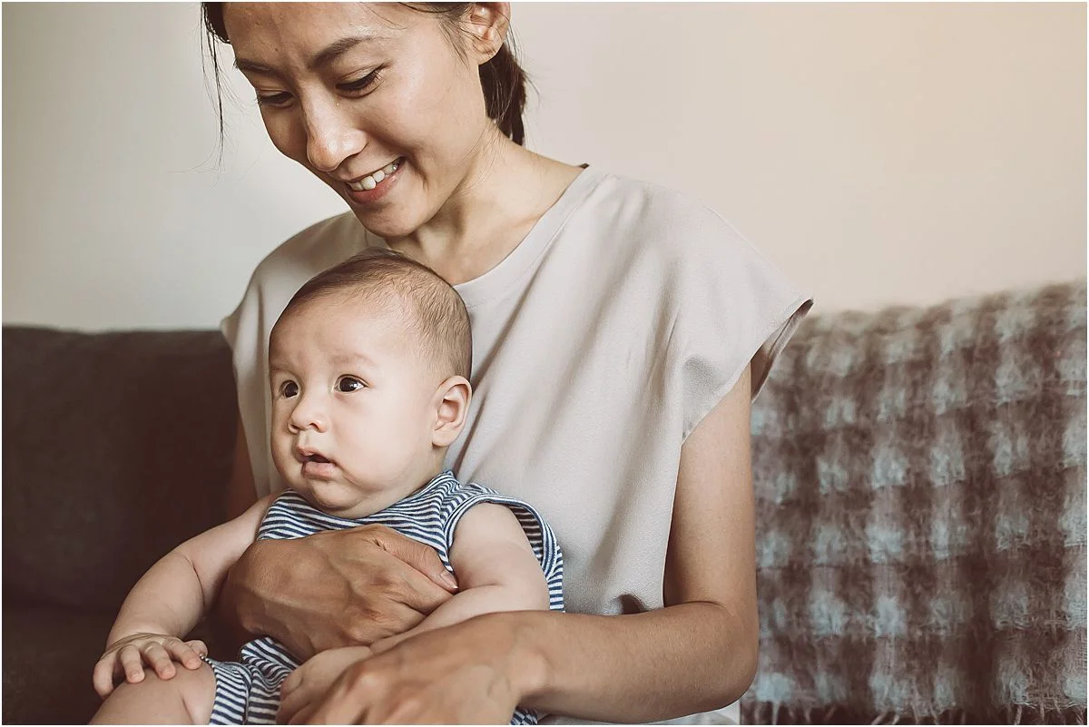 mom and son portrait sitting cozy on the couch in their downtown manhattan abode. image by nyc family photographer krystil mcdowall