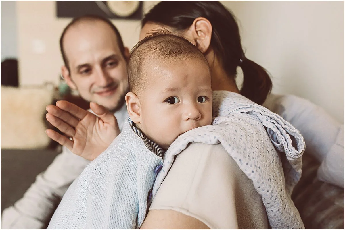 mom holding son closely while dad looks on lovingly at his beautiful wife and son. image by nyc family photographer