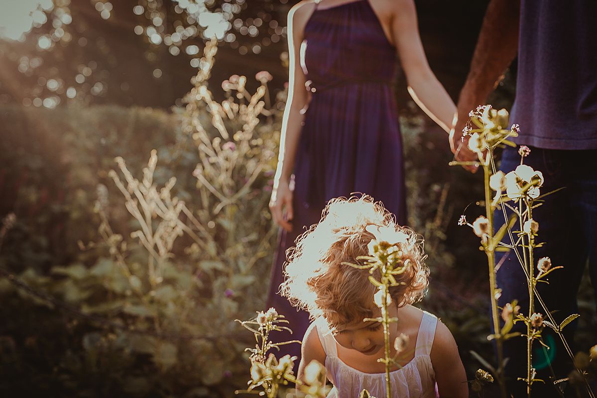 sun shines on toddler's curly hair during family session in fort tryon park. image by krystil mcdowall photography