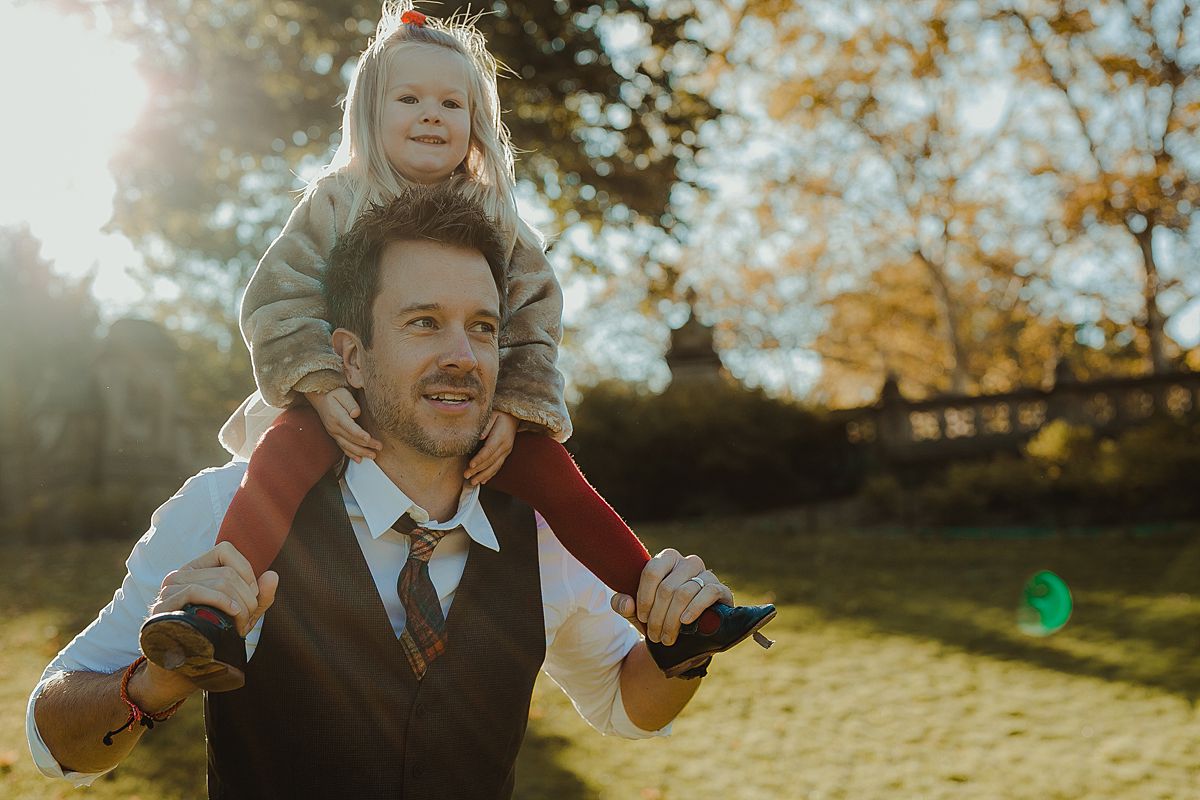 daughter gets piggy back from dad in central park nyc. image by krystil mcdowall photography