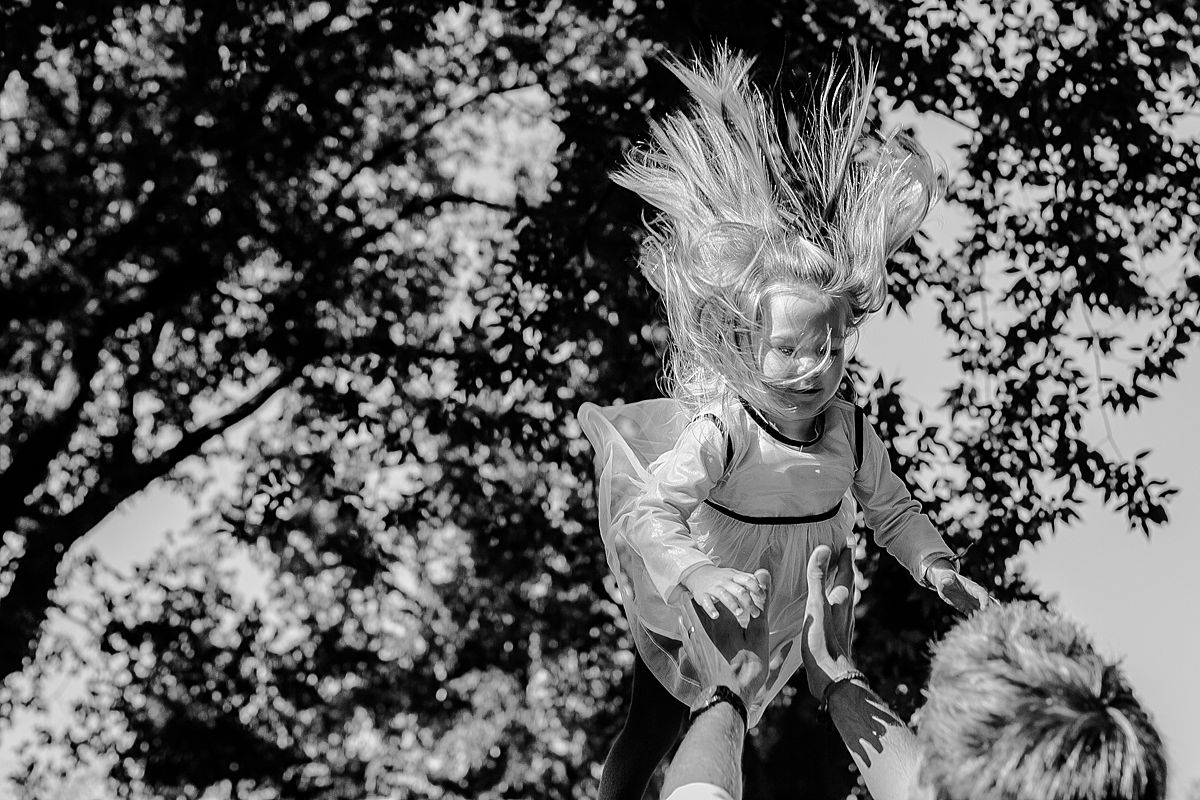 dad throws daughter in the air in candid family photo session with krystil mcdowall photography