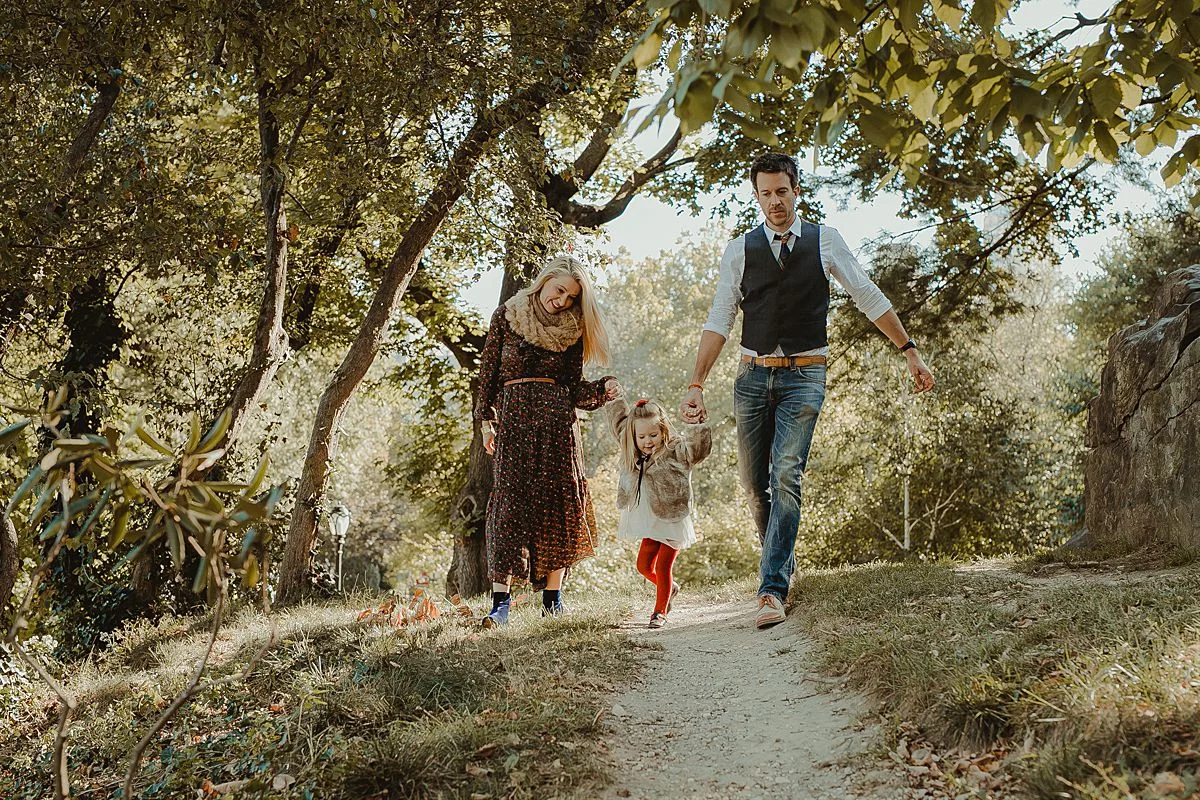 candid family photo as family walks though trails in central park. image by nyc family photographer krystil mcdowall