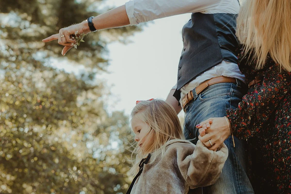 candid family photo as family walks though trails in central park. image by nyc family photographer krystil mcdowall
