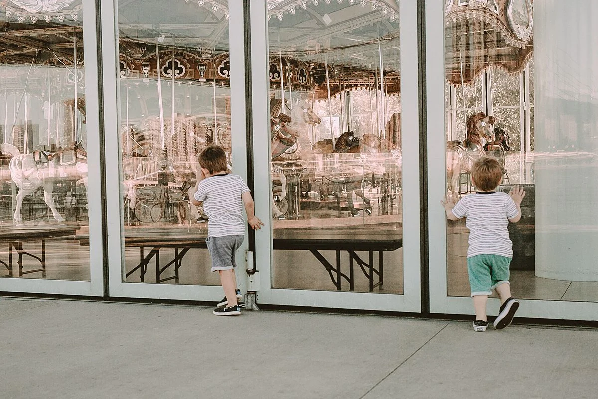 boys exploring jane's carousel at the brooklyn promenade. photo by nyc family and newborn photographer