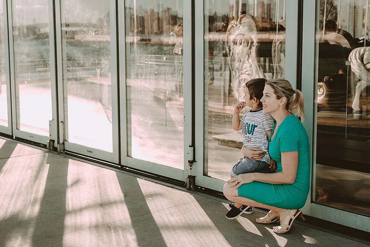 mom and son exploring jane's carousel at the brooklyn promenade. photo by nyc family and newborn photographer