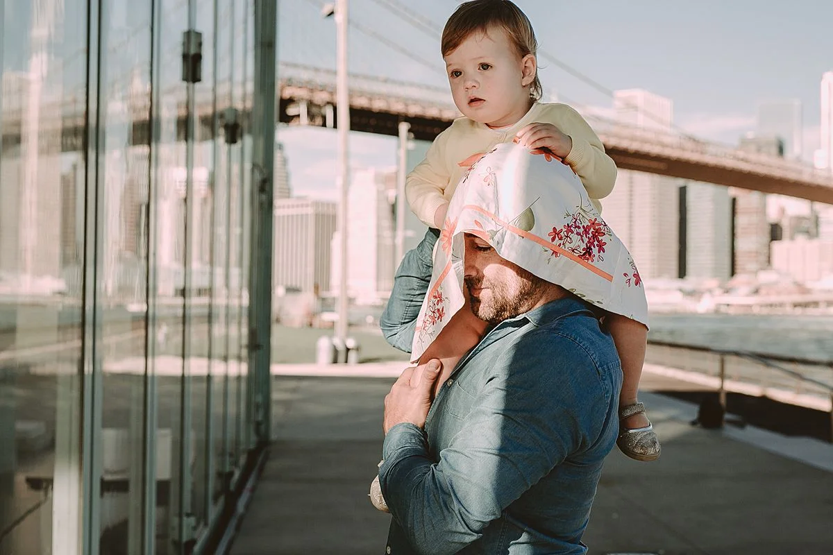 dad and daughter exploring jane's carousel at with daughter getting shoulder ride from dad. photo by nyc family photographer krystil mcdowall