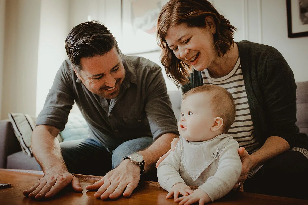 mom, dad and son play in living room together during candid family photo session in queens. krystil mcdowall photography capturing candid family photos