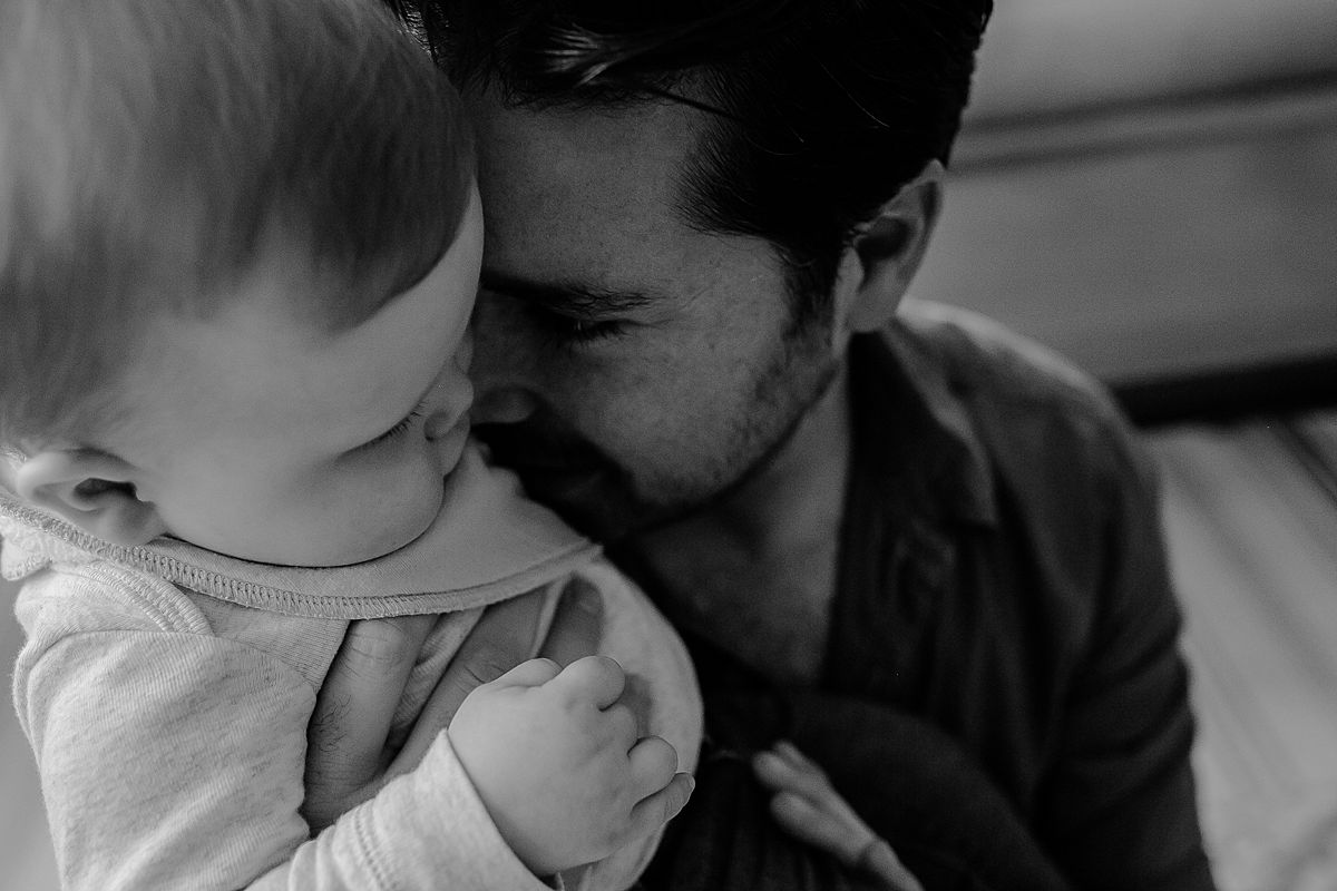 close up photo of dad snuggling into baby son during documentary family photo session with nyc family photographer krystil mcdowall