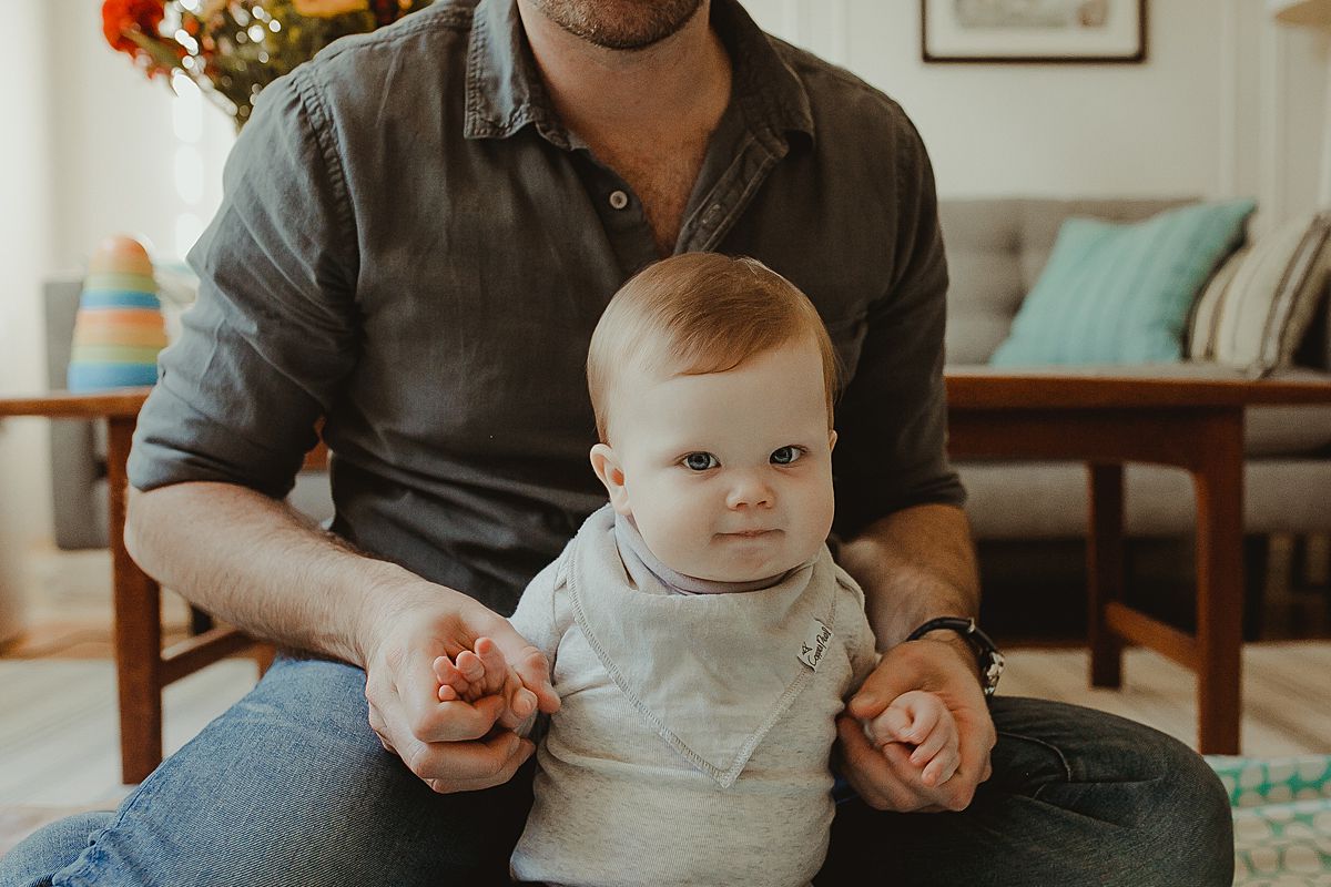 portrait of baby son in living room during in home family photo session in queens