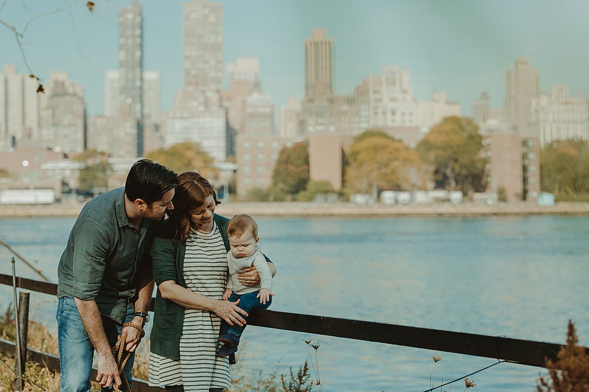 family portrait at socrates sculpture park with manhattan skyline in the background. image by nyc family and newborn photographer krystil mcdowall