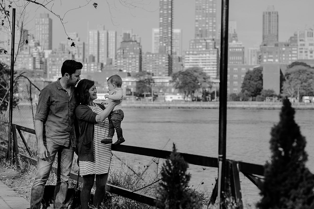 black and white family portrait at socrates sculpture park with manhattan skyline in the background. image by nyc family photographer krystil mcdowall