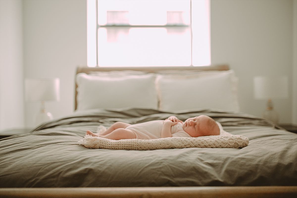 six week newborn girl sleeps on mom and dad's bed of downtown manahttan apartment. image by nyc newborn photographer krystil mcdowall photography