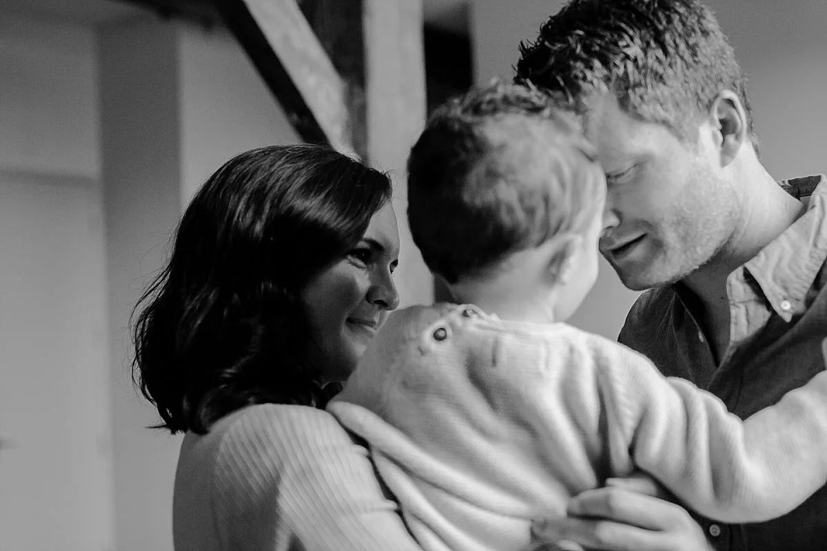 candid photo of mom and dad playing with son. image by nyc family photographer krystil mcdowall
