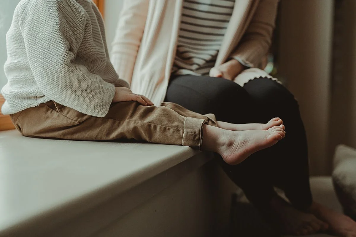 photo of toddler and mom feet as they sit by window at home. photo by nyc family photographer krystil mcdowall