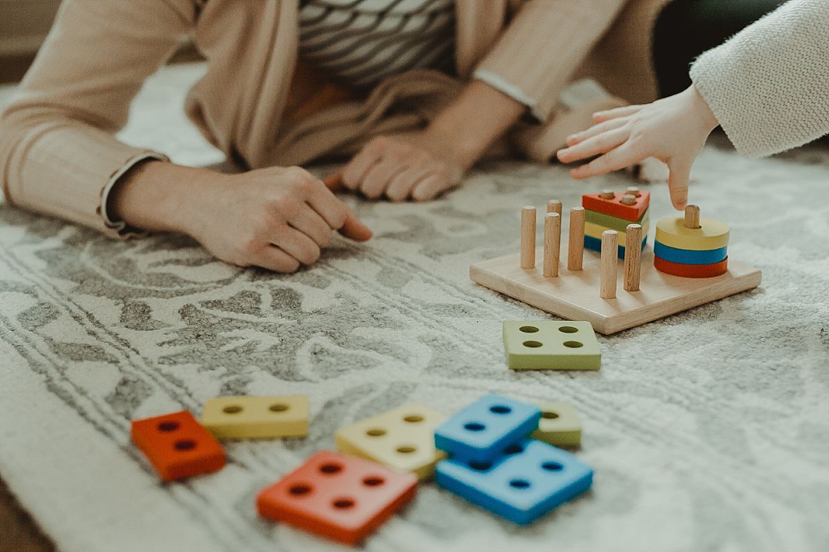 photo of mom and son's hands and toddler plays with shape sorter toy