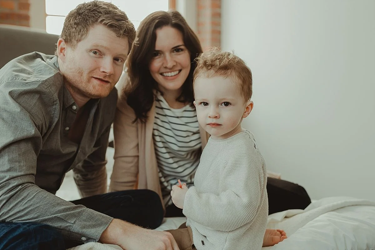 family portrait of mom, dad and son as they sit in parents room. krystil mcdowall captures beautiful portraits for your family