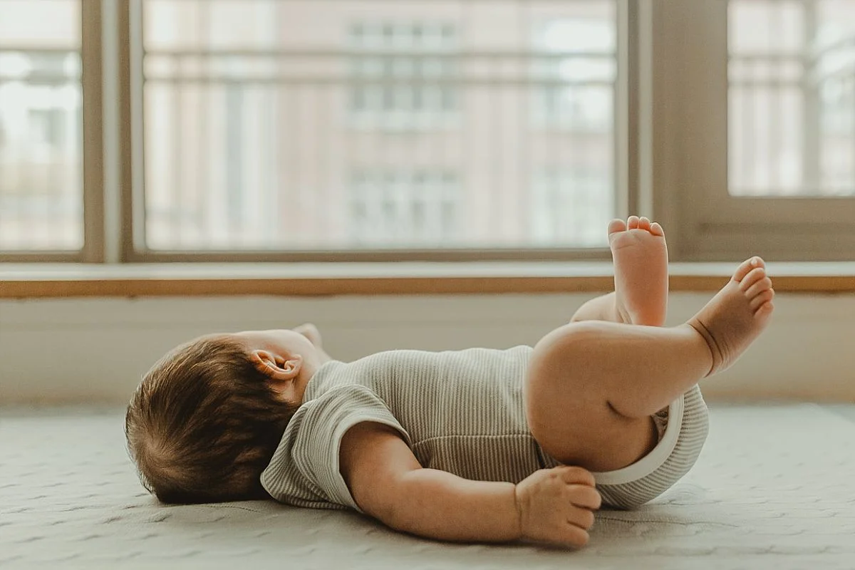 full portrait of newborn as he lies down looking out the window. image by nyc newborn photographer krystil mcdowall
