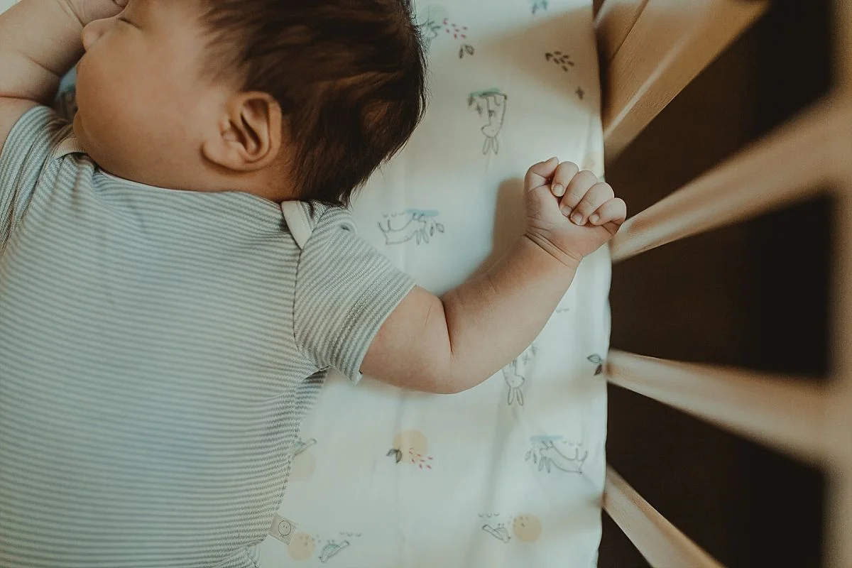 photo of newborn baby hand as he sleeps in his wooden crib. photo by nyc newborn photographer krystil mcdowall