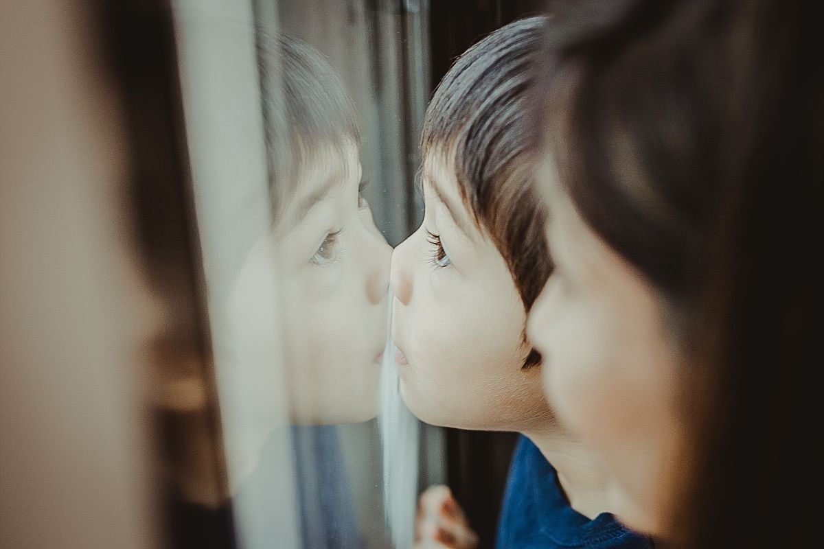 candid moment of mom and son steam writing on the window of their midtown manhattan hotel. krystil mcdowall photography captures candid family moments