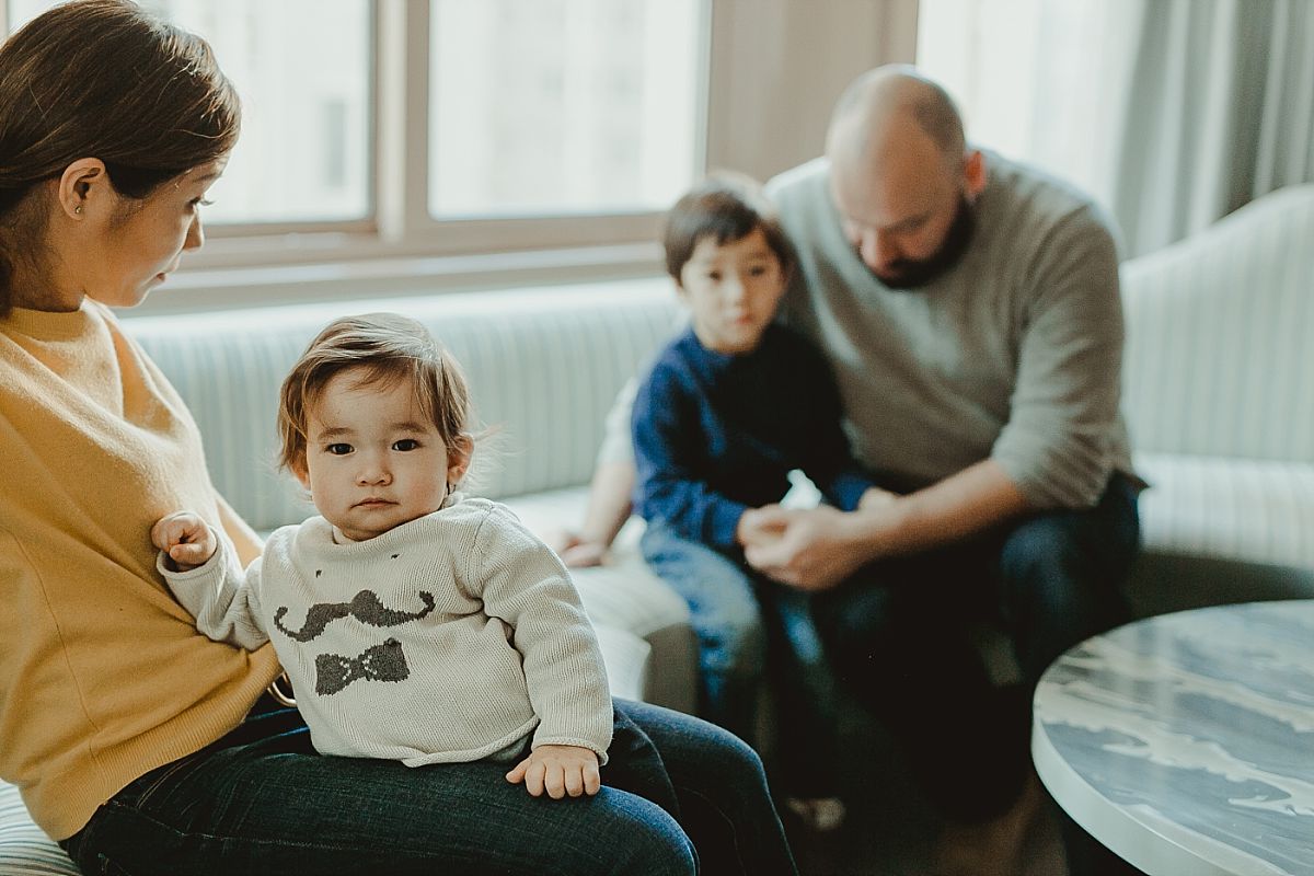 photo of dad, son, mom and daughter on hotel sofa lounge of their midtown manhattan apartment. image taken by nyc family photographer krystil mcdowall
