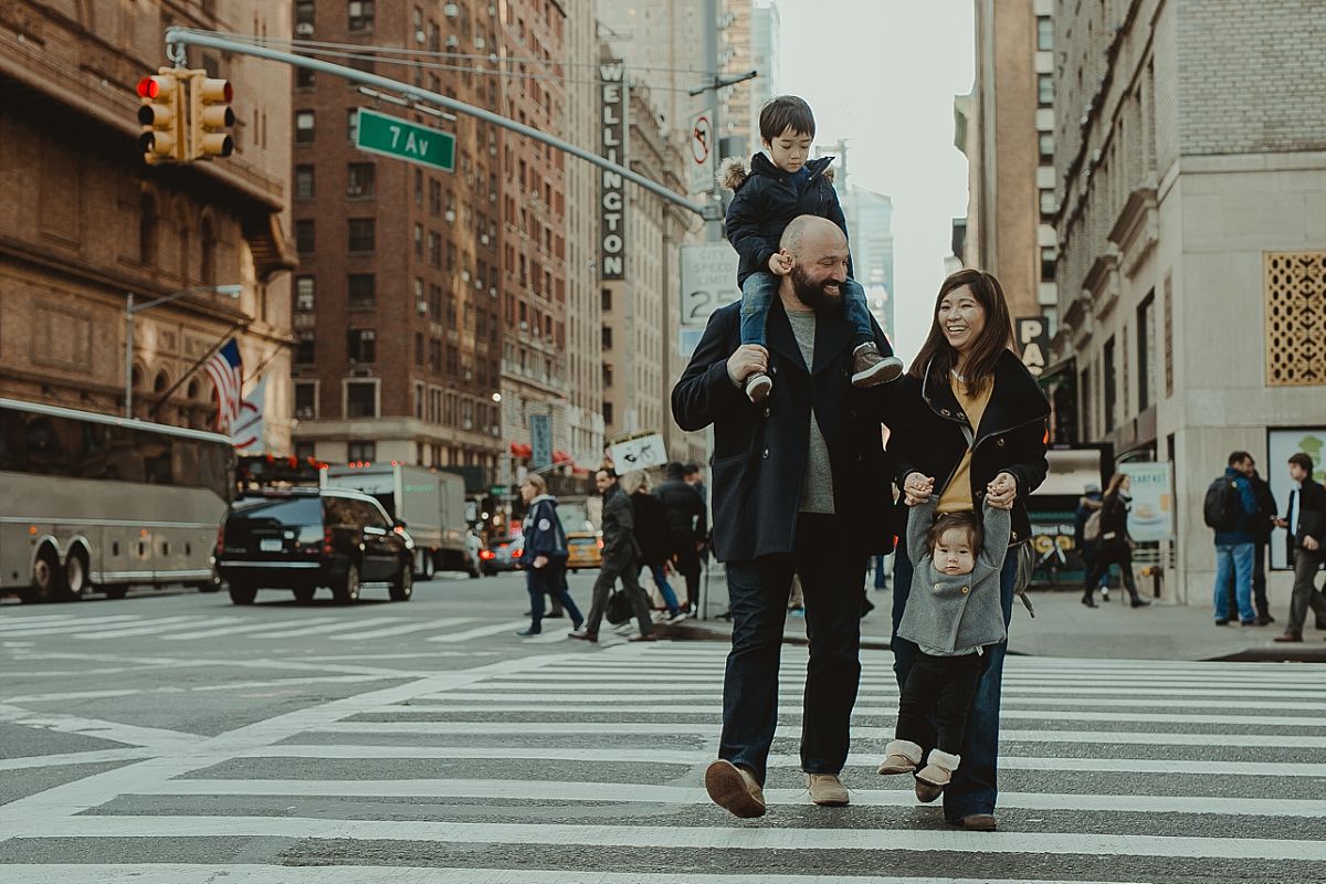 family of four walking the streets of midtown and laughing while they do so. image taken by photographer krystil mcdowall