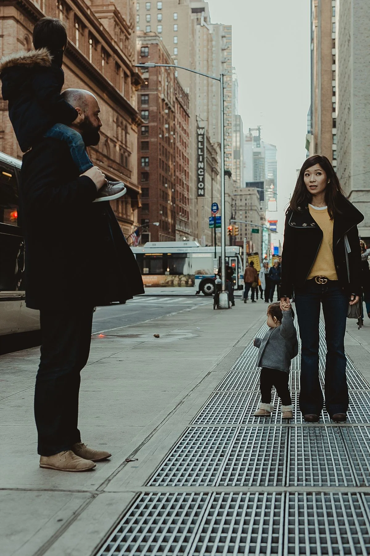 candid image of family of four walking the streets of midtown manhattan on a cold winter's day. image by nyc family photographer krystil mcdowall
