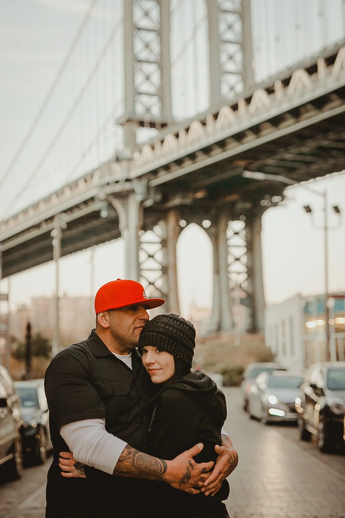 close up portrait of girlfriend leaning head on boyfriend's chest in front of manhattan bridge as sun begins to set. photo by nyc family photographer krystil mcdowall