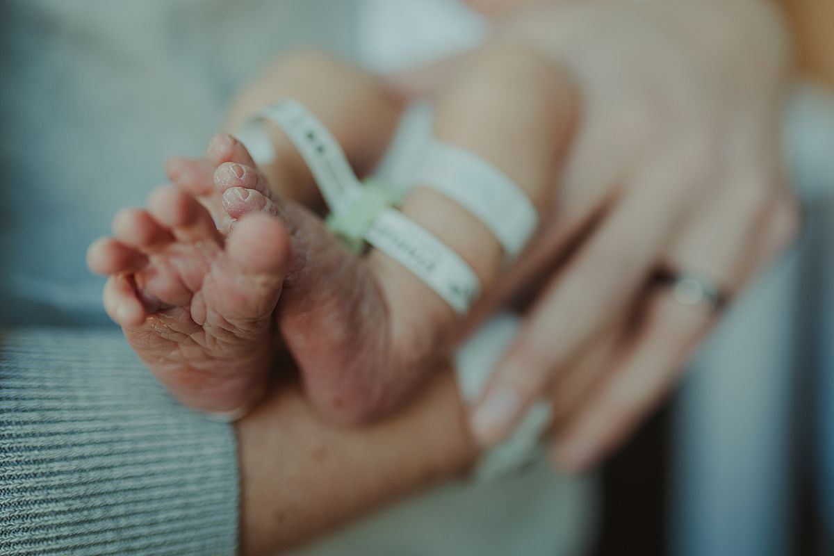 fresh 48 photo of newborn baby boy feet being held by his dad in nyc hospital. photo by nyc family and newborn photographer krystil mcdowall