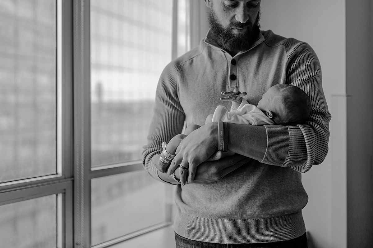 fresh 48 photo of newborn baby boy and his dad standing by bright nyc hospital window when baby was 2 days old. photo by nyc family and newborn photographer krystil mcdowall