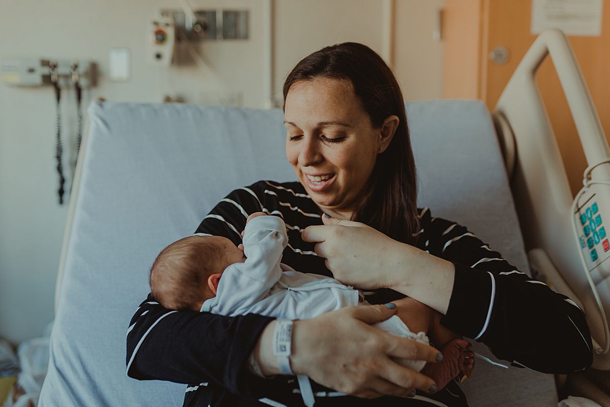 fresh 48 photo of mom playing with hand of newborn baby boy in nyc hospital when baby was 2 days old. photo by nyc family and newborn photographer krystil mcdowall