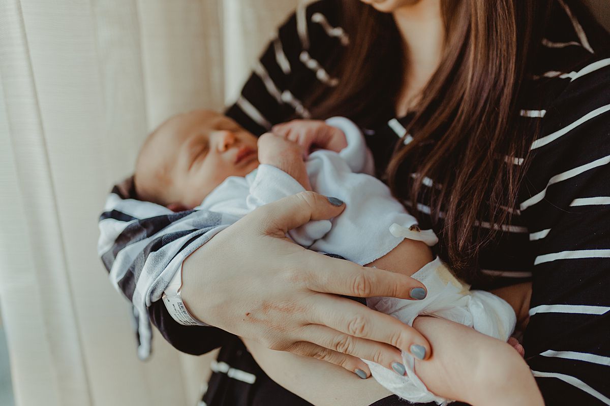 close up photo of newborn son being held by his mom at the hospital. photo by nyc family and newborn photographer krystil mcdowall