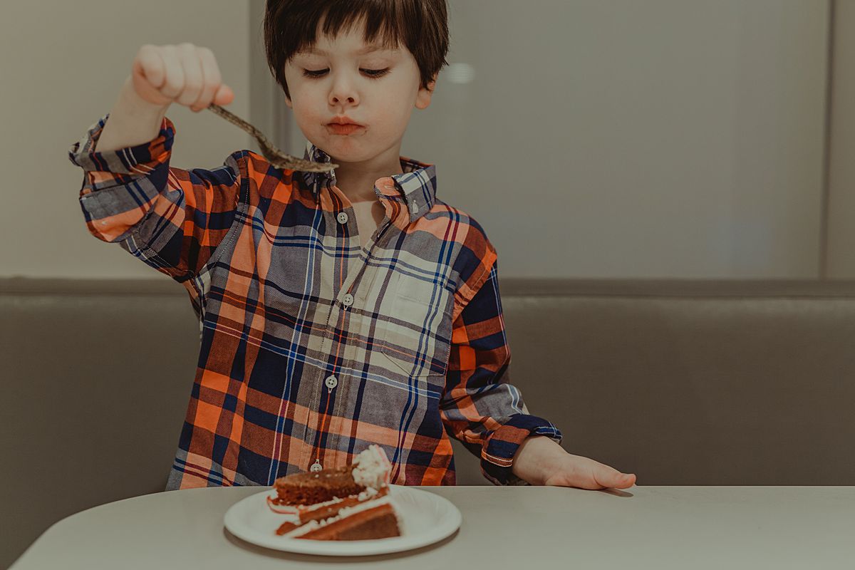 photo of boy eating sister's one year old birthday cake. photo by nyc family and newborn photographer Krystil McDowall