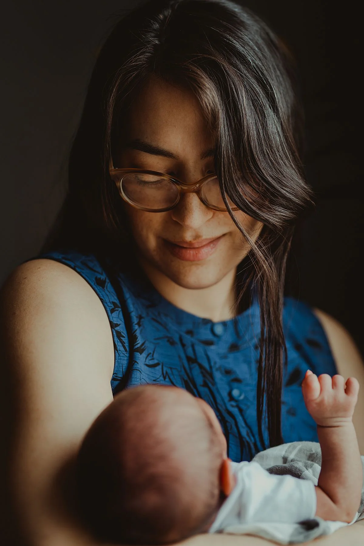 color portrait of mom and newborn baby boy in mom's arms during in home newborn photo session in nyc. photo by nyc family and newborn photographer krystil mcdowall