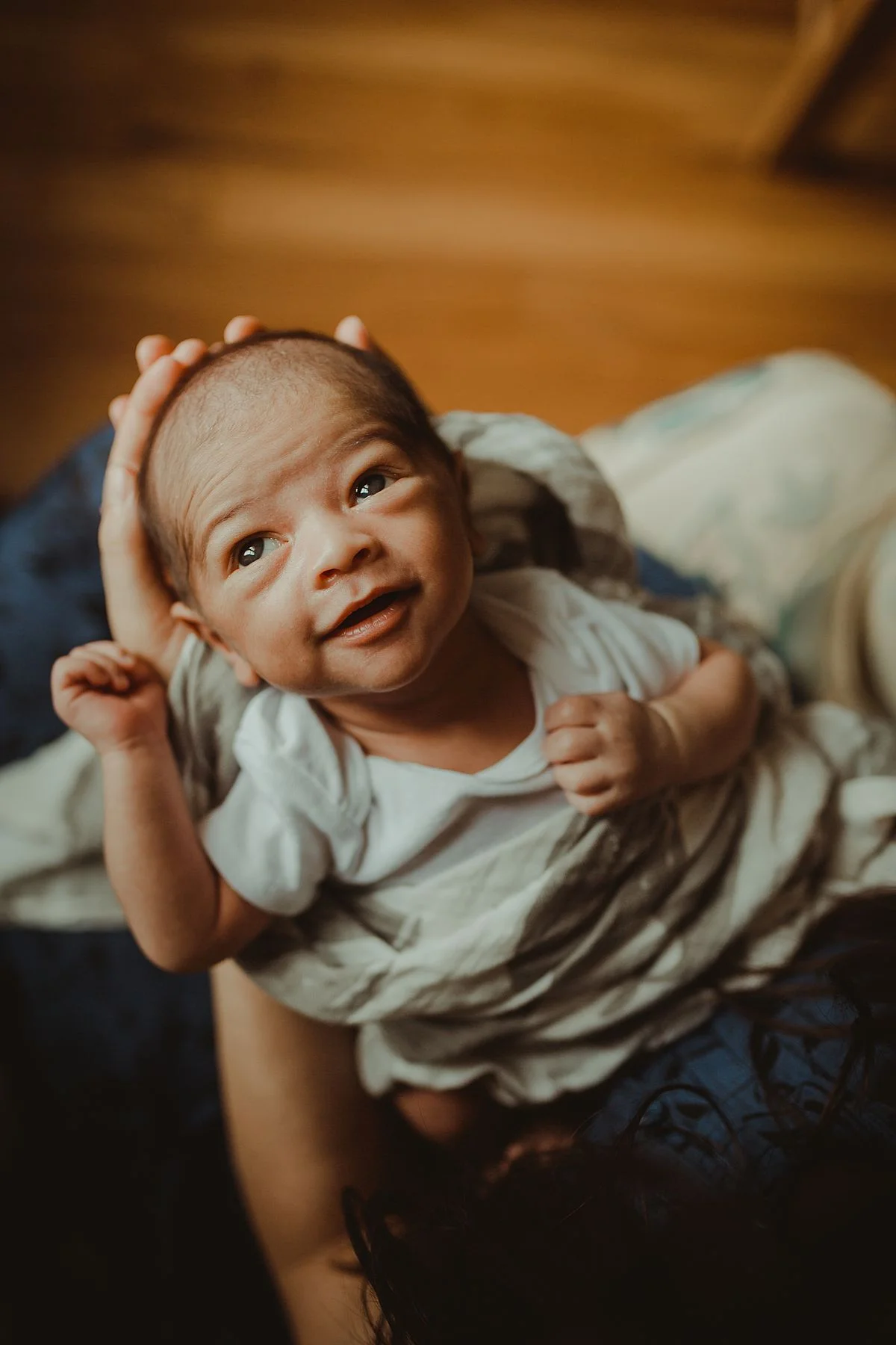 portrait of newborn smiling and looking out the window of his new home in washington heights. photo by nyc family and newborn photographer krystil mcdowall
