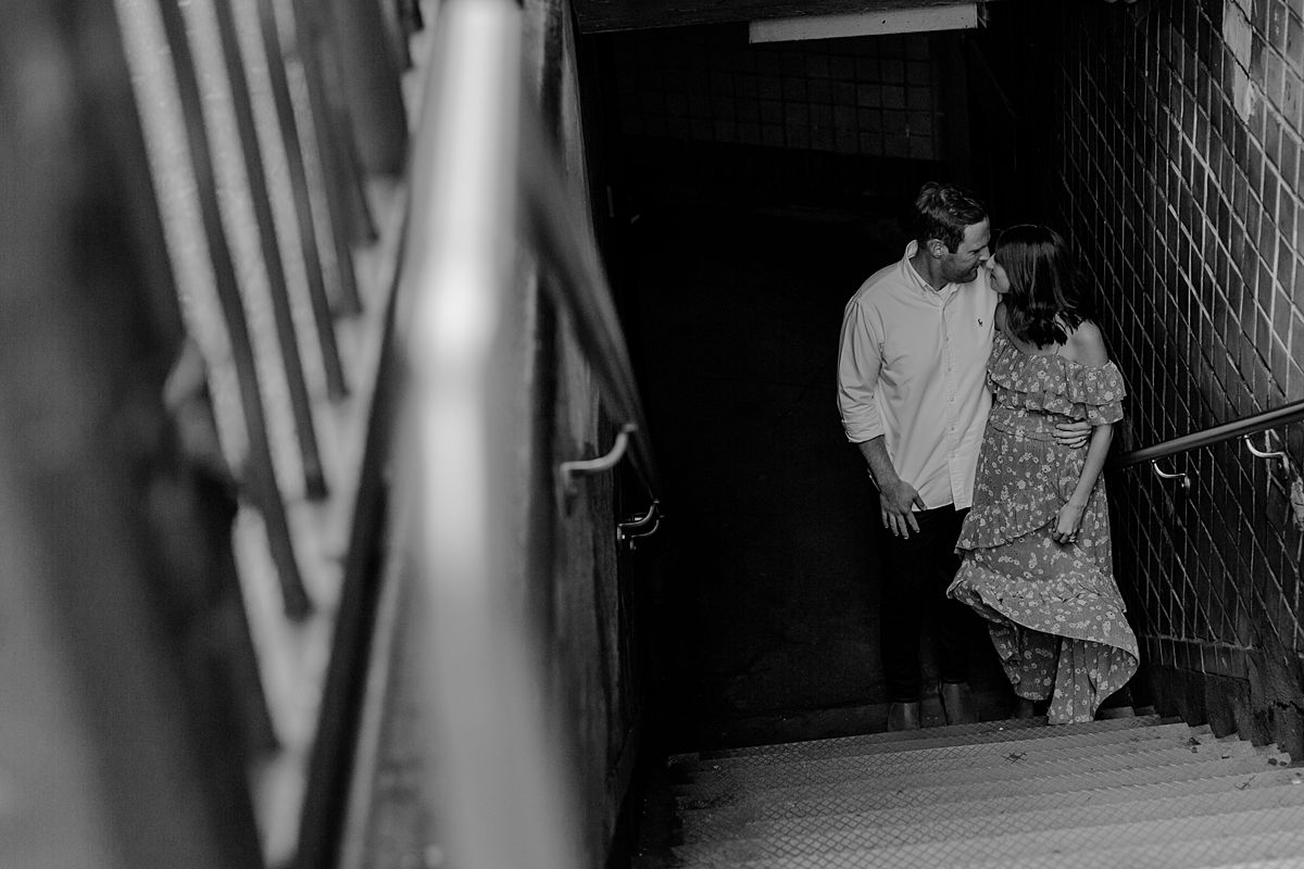 expecting couple in front of entrance to subway station at west 72nd street just off of central park west nyc. maternity photo by nyc family and newborn photographer krystil mcdowall