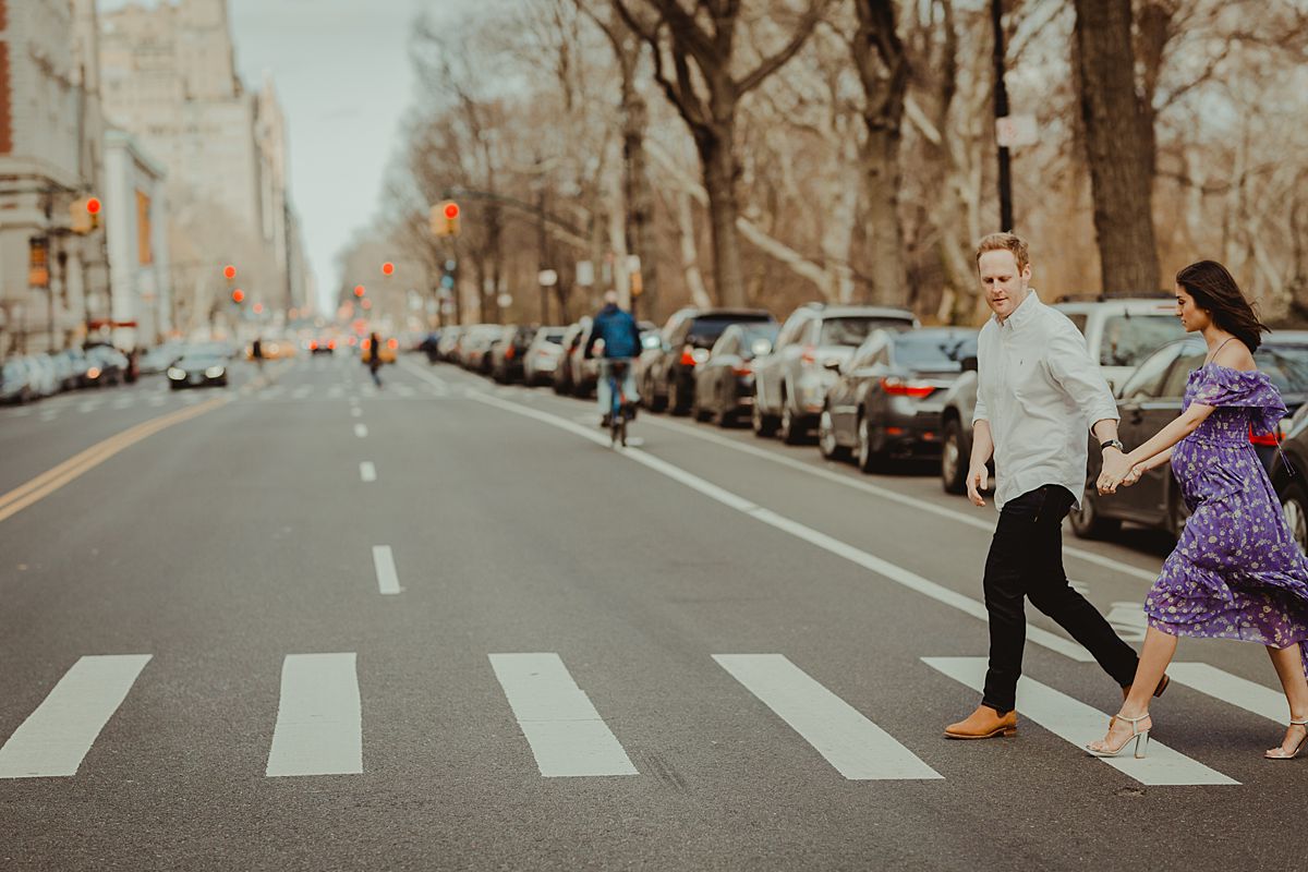 expecting couple walks along pedestrian crossing at 72nd street on central park west. maternity photo by nyc family and newborn photographer krystil mcdowall