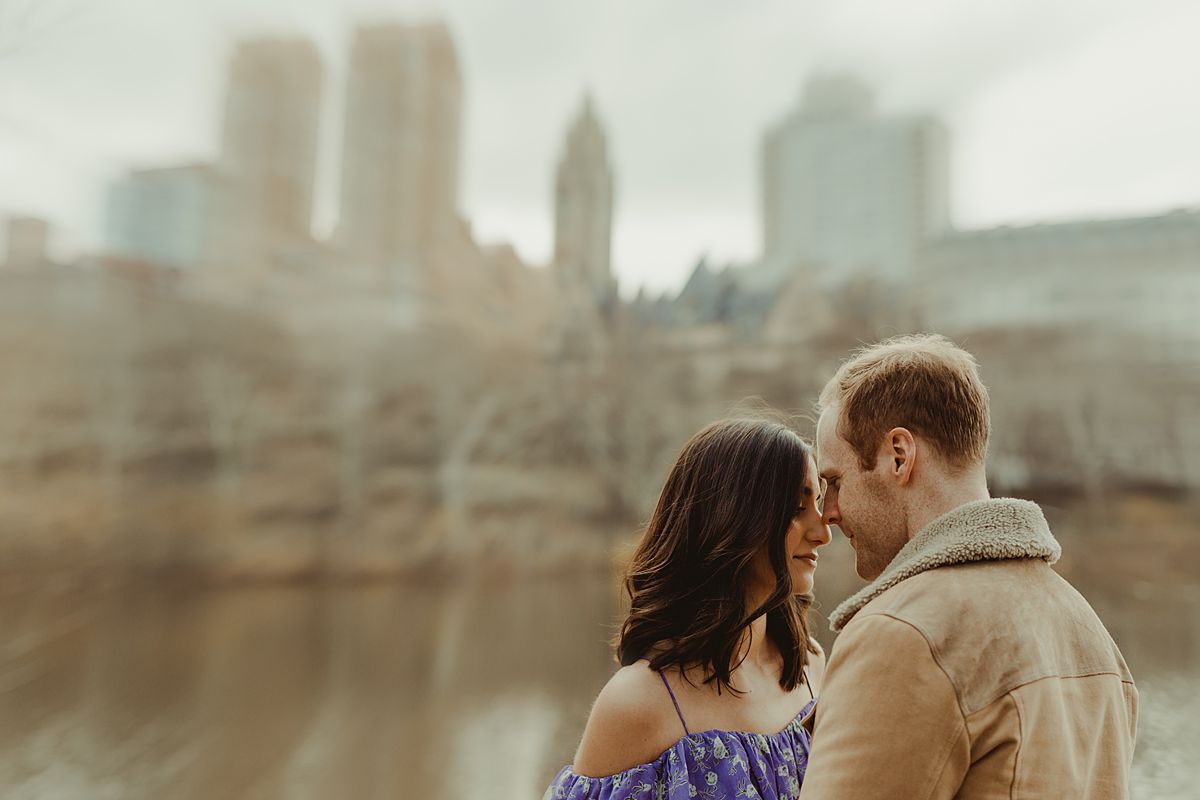 expecting couple stands in front of lake in central park during maternity photo session. image by nyc family and newborn photographer krystil mcdowall