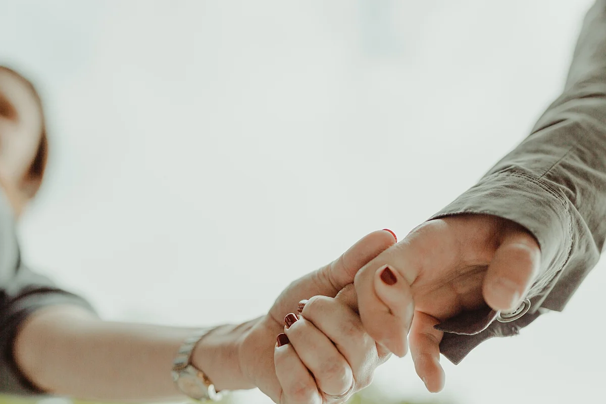 close up image of hands of expecting husband and wife as they walk in stuyvesant square park during maternity photo session. photo by nyc family and newborn photographer krystil mcdowall