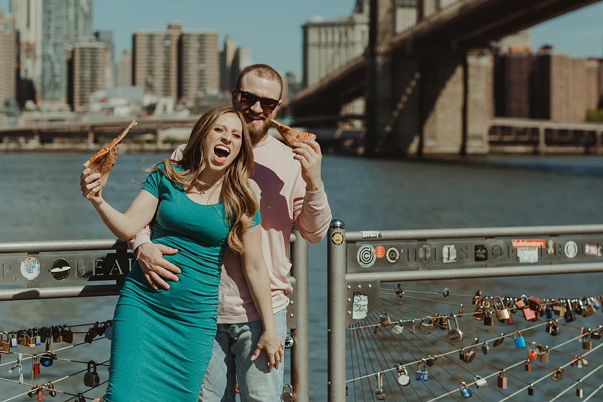 photo of pregnant couple eating pizza in brooklyn bridge park during maternity photo shoot. image by krystil mcdowall photography