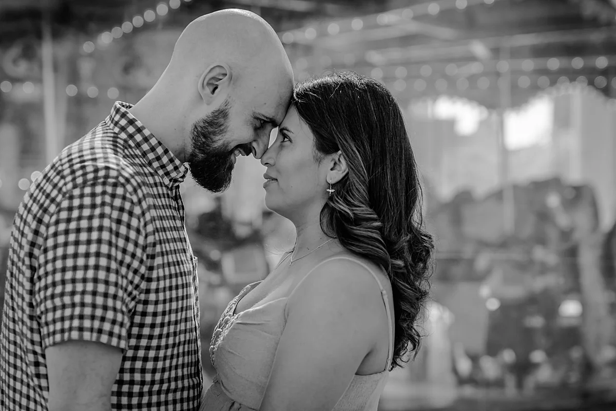 black and white portrait of married couple standing with their foreheads together and looking at each other lovingly during lifestyle maternity photo session with orange county family photographer krystil mcdowall