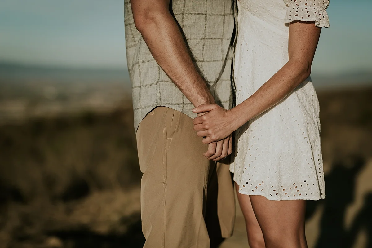 photo by Orange County family photographer Krystil McDowall. Details photo of mom and dad holding hands during family lifestyle photo session at Top of the World Laguna Beach California