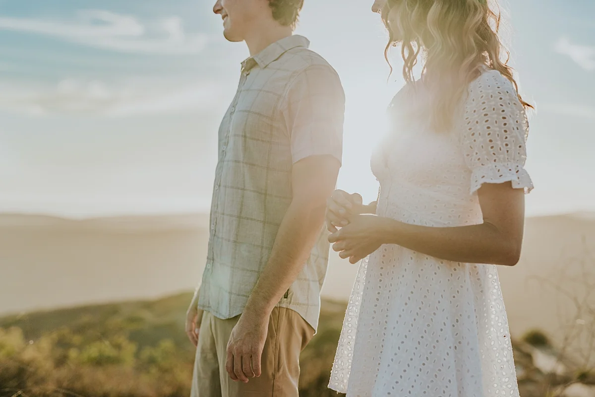 photo by Orange County family photographer Krystil McDowall Photography. Photo of mom and dad with the sun shinging through the background during lifestyle family photo session
