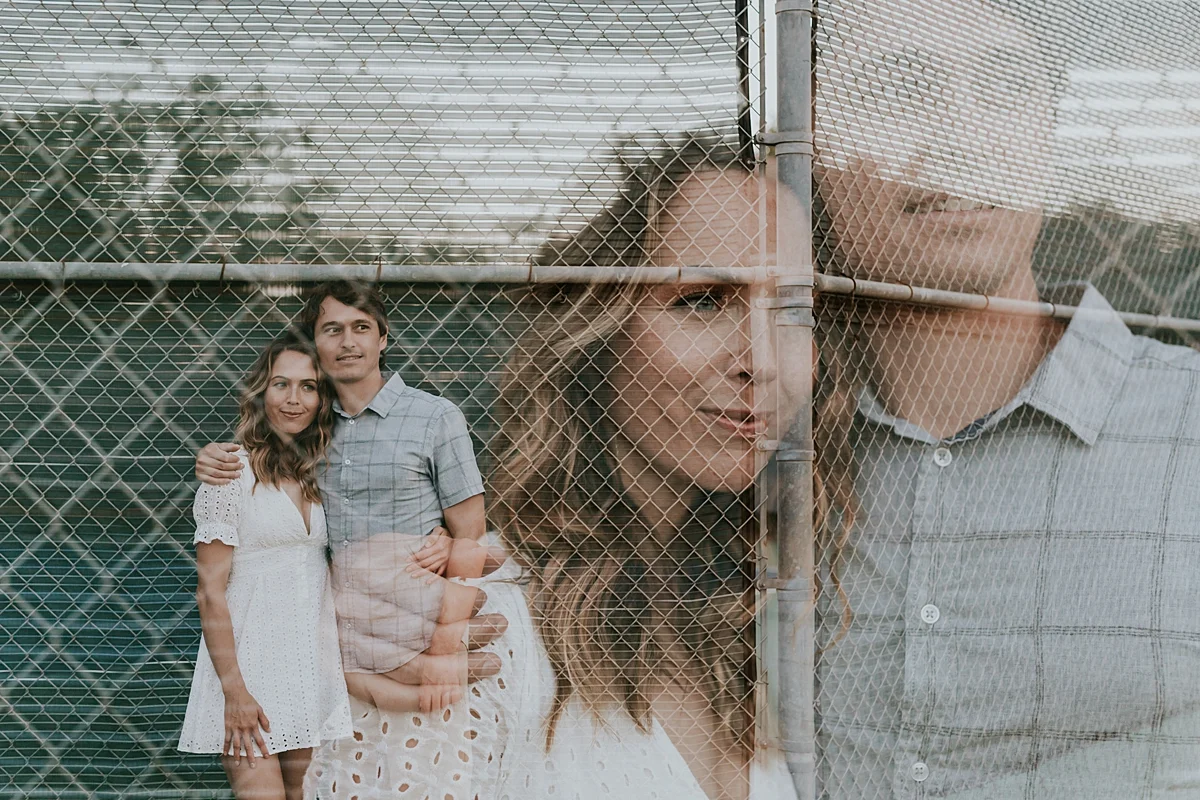 photo by Orange County family photographer Krystil McDowall Photography. double exposure photo of husband and wife standing in front of the tennis court at Top of the World Laguna Beach California