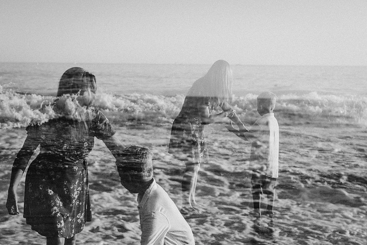 orange county family photographer. double exposure photo of mom and her son playing in the shallow ocean waves at Corona del Mar State Beach