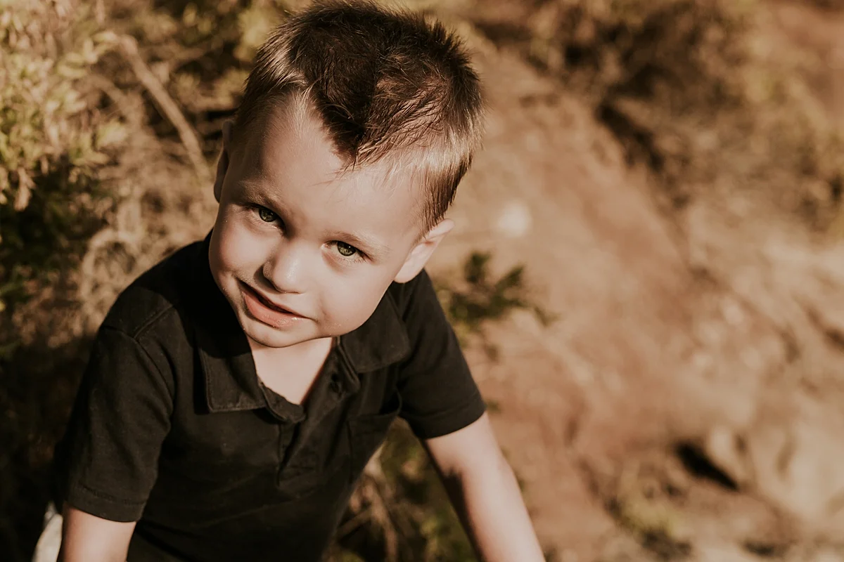 orange county family photographer. portrait of young boy with beach bluffs in the background at Corona del Mar State Beach with Krystil McDowall Photography