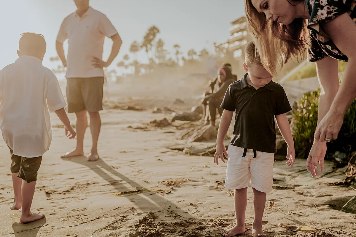 orange county family photographer candid photo of family of four packing up to leave corona del mar state beach california